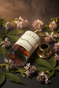 Perfume bottle labeled 'Fiora Paradise' by Qaymar on a dark textured surface.