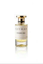 Perfume bottle labeled 'Qaymar Golden Silk' on a dark textured surface